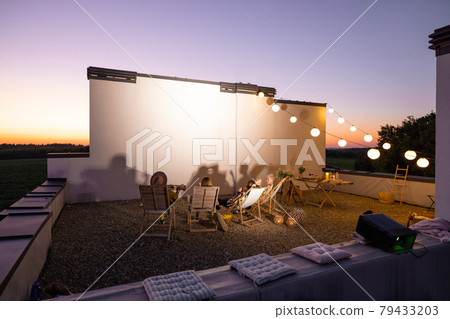 People watching movie on the rooftop terrace at sunset People watching movie on the rooftop terrace at sunset 79433203
