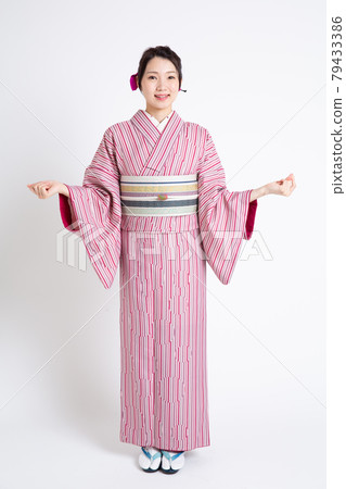 A young Japanese woman wearing a small crest and spreading her hands A young Japanese woman wearing a small crest and spreading her hands 79433386