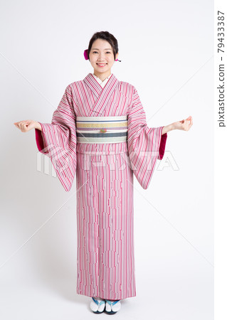 A young Japanese woman wearing a small crest and spreading her hands 79433387