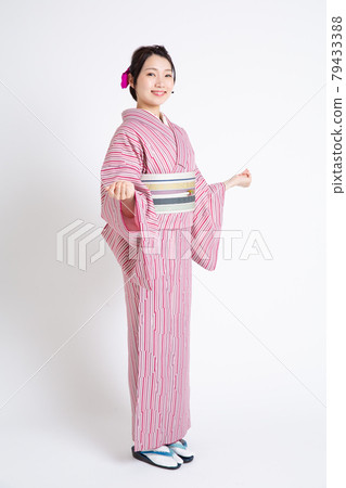 A young Japanese woman wearing a small crest and spreading her hands A young Japanese woman wearing a small crest and spreading her hands 79433388