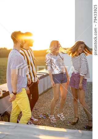 Friends dancing at rooftop terrace on sunset 79433925