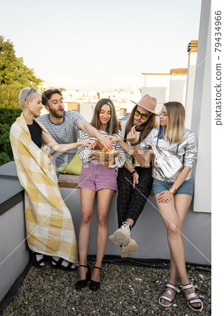 Friends hang out together at rooftop on a sunset Friends hang out together at rooftop on a sunset 79434966