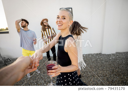Stylish friends dancing at party outdoors 79435170