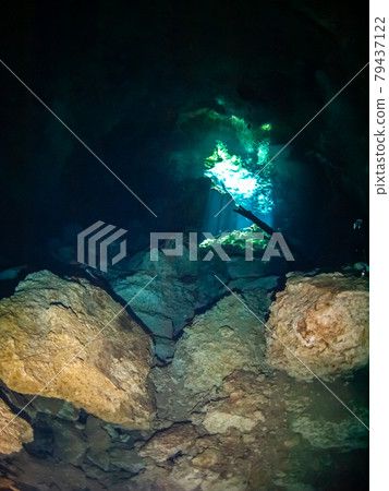 Underwater cave (Cenote) where sunlight shines through a hole in the ceiling (Playa del Carmen, Mexico) 79437122