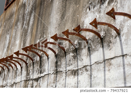 sharp steel spikes on concrete wall sharp steel spikes on concrete wall 79437921
