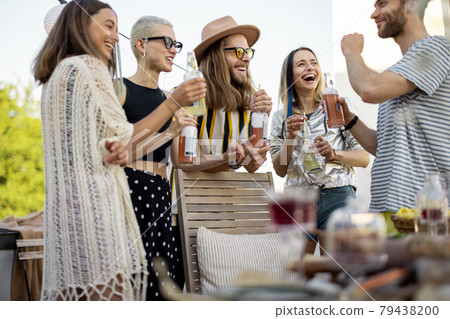 Young stylish friends having a festive dinner on the roof terrace Young stylish friends having a festive dinner on the roof terrace 79438200