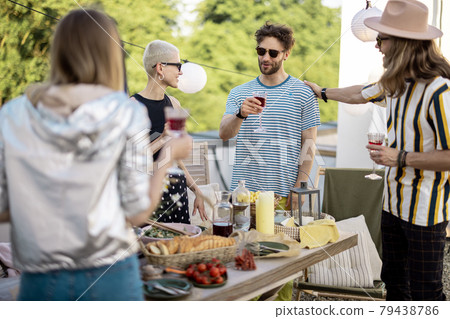 Young stylish friends having a festive dinner on the roof terrace 79438786
