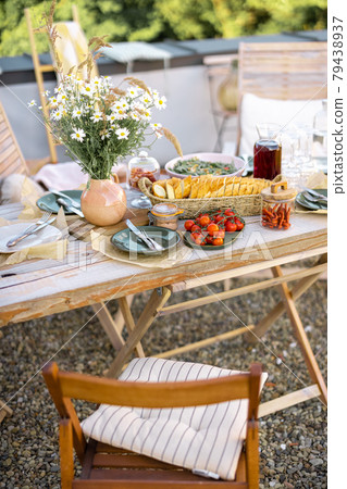 Beautifully served wooden table with food and dishes in natural boho style outdoors Beautifully served wooden table with food and dishes in natural boho style outdoors 79438937