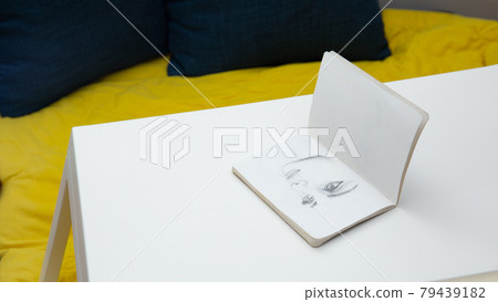 Face sketching on notebook top view Face sketching on notebook top view 79439182