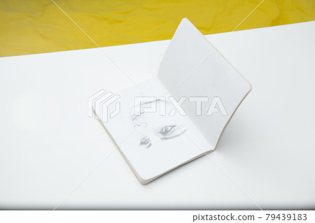 Face sketching on notebook top view Face sketching on notebook top view 79439183