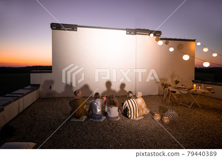 People watching movie on the rooftop terrace at sunset 79440389