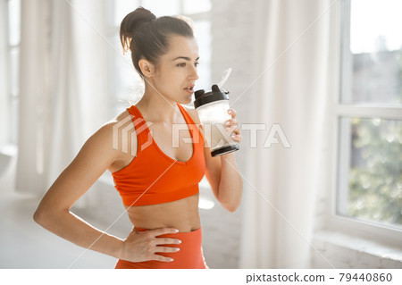 Sports woman with protein shaker at gym 79440860