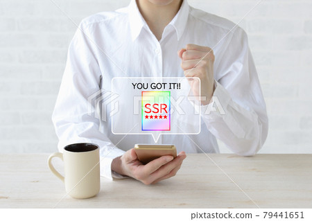 A woman who is pleased to get a rare character in a smartphone game 79441651