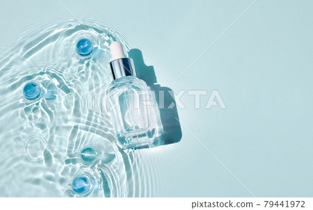 Mockup of cosmetic glass blue bottle with pipette and serum on water surface with waves. Advertising of medical product anti-aging moisturizing care 79441972
