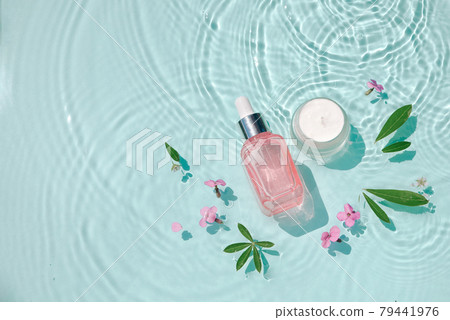 Moisturizing cosmetic products on water with drops. Serum glass bottle and cream jar on aqua surface Concept moisturizing summer beauty treatments Moisturizing cosmetic products on water with drops. Serum glass bottle and cream jar on aqua surface Concept moisturizing summer beauty treatments 79441976