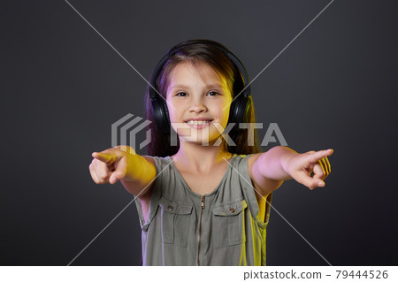 cute child girl in wireless headphones listening to music cute child girl in wireless headphones listening to music 79444526