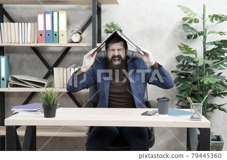 Control anger before it controls you. Businessman shout holding laptop on head.  79445360