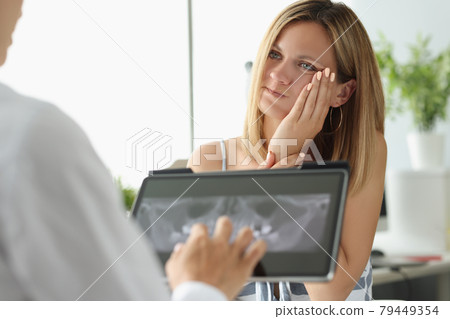 Female patient with acute toothache at doctor appointment with X-ray image 79449354