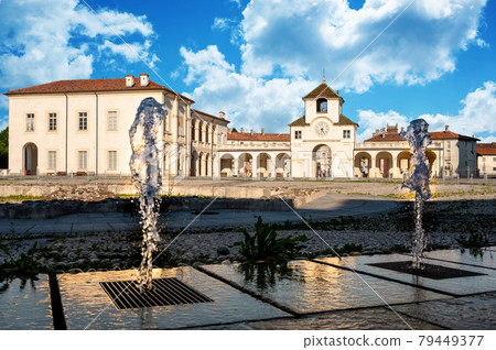 Venaria Reale,Piedmont,Italy. June 2021. Stunning view of the clock tower which is the entrance to the palace. On a beautiful sunny day with blue skies and white clouds, the jets of the fountain frame Venaria Reale,Piedmont,Italy. June 2021. Stunning view of the clock tower which is the entrance to the palace. On a beautiful sunny day with blue skies and white clouds, the jets of the fountain frame 79449377