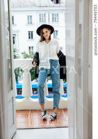 beautiful young woman in a black hat with fields and jacket beautiful young woman in a black hat with fields and jacket 79449703