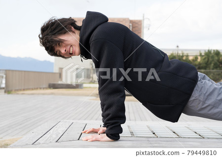 A man doing push-ups outdoors A man doing push-ups outdoors 79449810