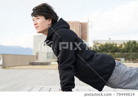 A man doing push-ups outdoors A man doing push-ups outdoors 79449814