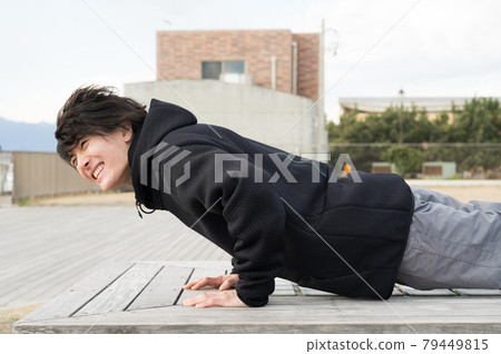 A man doing push-ups outdoors A man doing push-ups outdoors 79449815