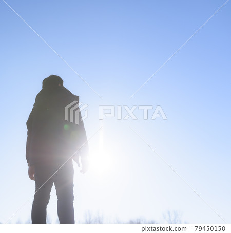 A man staring at the dazzling sun 79450150
