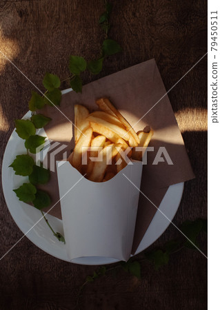 Top view of French fries. Fry dip. The concept of fast food, quick bites and restaurants for catering. Potatoes in carton and ketchup. Vertical photo. 79450511