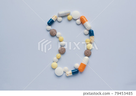 Medicine pills tablets capsules in shape of human kidney on gray background 79453485