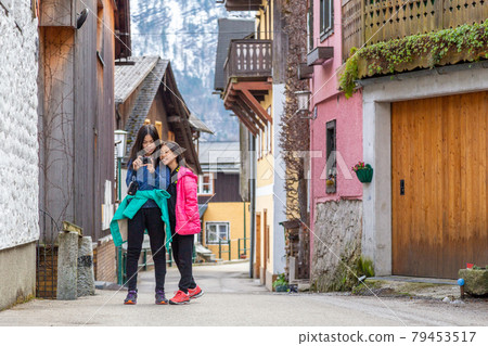 Two happy Asian sisters look at the photos they took on their camera in Hallstatt, Austria Two happy Asian sisters look at the photos they took on their camera in Hallstatt, Austria 79453517