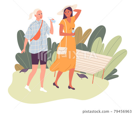 Two girls on a walk in the park in the hot summer. Friends walking, talking, one drinking water 79456963