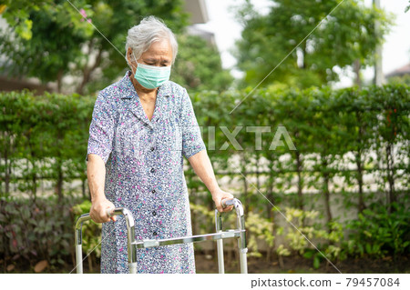 Asian senior or elderly old lady woman walk with walker and wearing a face mask for protect safety infection and kill Novel Coronavirus Covid-19 virus. 79457084
