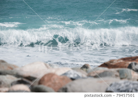 Blue-green waves rolling on the seashore 79457501