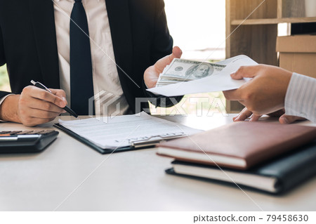 Entrepreneurs are signing a contract about business under fraud while colleagues give money in an envelope. 79458630