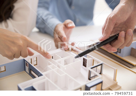 業主和設計師一邊看房子模型一邊開會 業主和設計師一邊看房子模型一邊開會 79459731