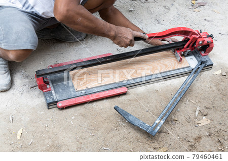 Worker cutting ceramic tile with tile cutter tool Worker cutting ceramic tile with tile cutter tool 79460461