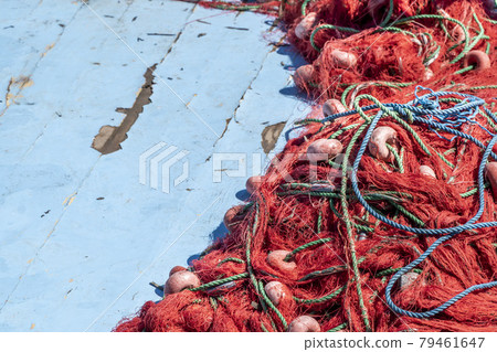 pile of red fishing nets on blue wooden background with copy space 79461647