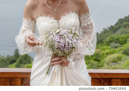 closeup hands of a bride holding wedding flower bouquet closeup hands of a bride holding wedding flower bouquet 79461648