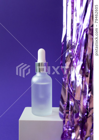 Serum mockup with pipette and holiday tinsel on cube podium on violet background, vertical 79462605