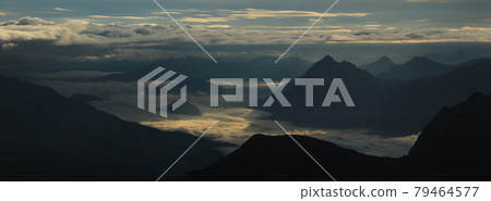 Sunrise view from Mount Brienzer Rothorn. Mount Stanserhorn and sea of fog on a cloudy summer morning. 79464577