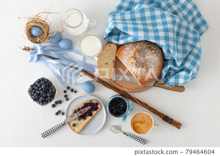 Easter breakfast or brunch table in blue style, embellished with Easter symbols,  traditional Czech Easter pastry Mazanec, Pomlazka and eggs. 79464604