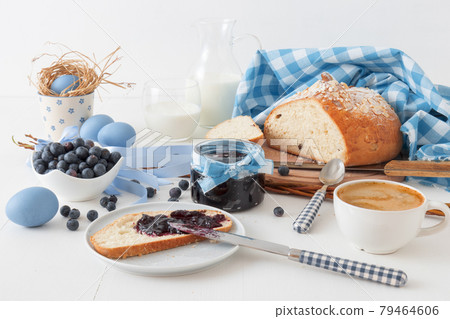 Easter breakfast or brunch table in blue style, embellished with Easter symbols, traditional Czech Easter pastry Mazanec, Pomlazka and eggs. Easter breakfast or brunch table in blue style, embellished with Easter symbols, traditional Czech Easter pastry Mazanec, Pomlazka and eggs. 79464606