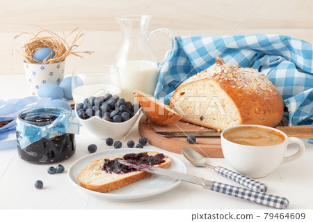 Easter breakfast or brunch table in blue style, embellished with Easter symbols, traditional Czech Easter pastry Mazanec, Pomlazka and eggs. Easter breakfast or brunch table in blue style, embellished with Easter symbols, traditional Czech Easter pastry Mazanec, Pomlazka and eggs. 79464609