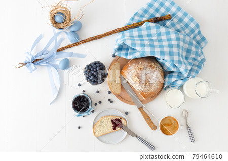 Easter breakfast or brunch table in blue style, embellished with Easter symbols, traditional Czech Easter pastry Mazanec, Pomlazka and eggs. Easter breakfast or brunch table in blue style, embellished with Easter symbols, traditional Czech Easter pastry Mazanec, Pomlazka and eggs. 79464610