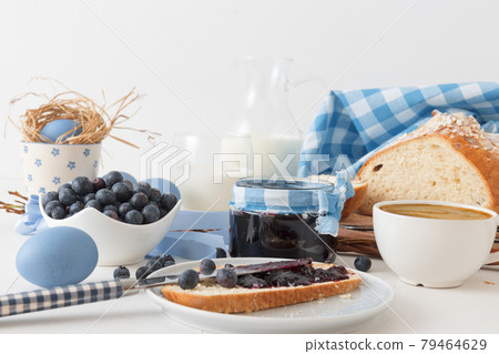 Easter breakfast or brunch table in blue style, embellished with Easter symbols, traditional Czech Easter pastry Mazanec, Pomlazka and eggs. Easter breakfast or brunch table in blue style, embellished with Easter symbols, traditional Czech Easter pastry Mazanec, Pomlazka and eggs. 79464629