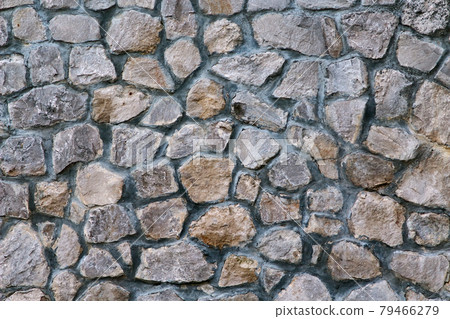 Texture of a stone wall. Part of old castle stone wall background. Gray stone siding with different sized stones. 79466279