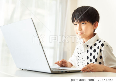 A boy who operates a laptop computer A boy who operates a laptop computer 79467268