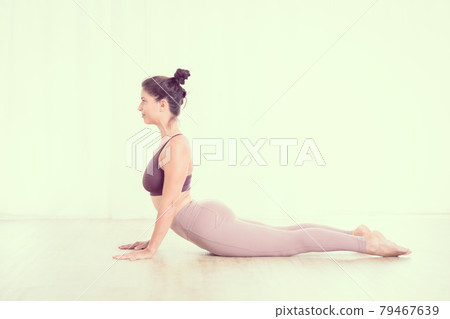 Portrait of gorgeous active sporty young woman practicing yoga in studio. Beautiful girl practice Sasangasana, rabbit yoga pose. Healthy active lifestyle, working out indoors in gym Portrait of gorgeous active sporty young woman practicing yoga in studio. Beautiful girl practice Sasangasana, rabbit yoga pose. Healthy active lifestyle, working out indoors in gym 79467639