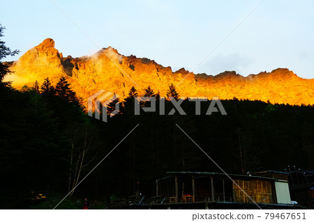 Yatsugatake Yokodake and ridgeline dyed red in the setting sun seen from Akadake mineral spring 79467651